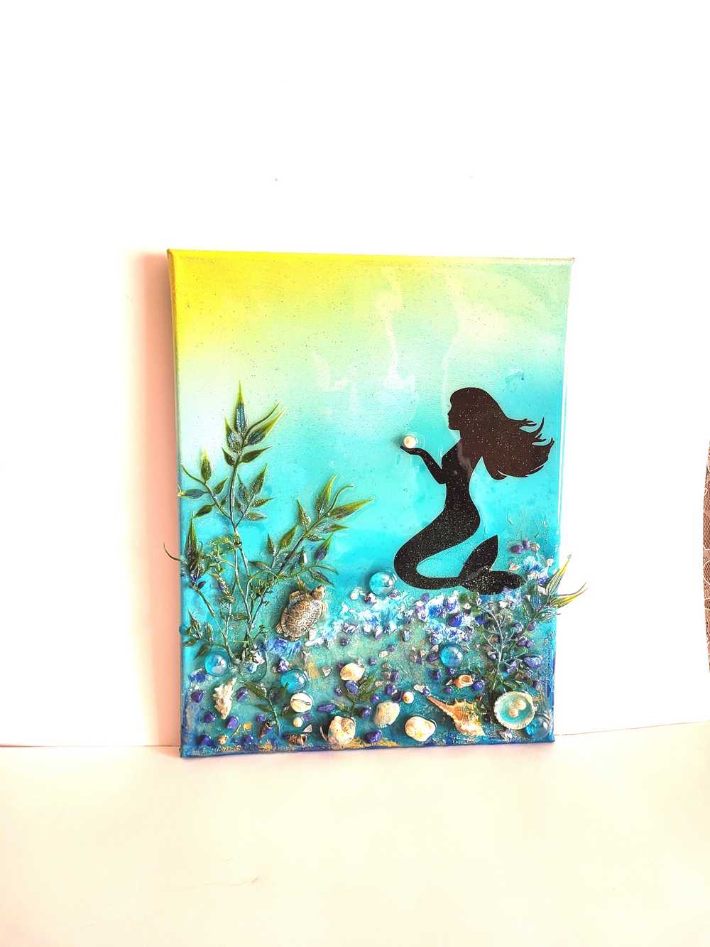 3D Resin Canvas Art of a Beautiful Silhouette of a Mermaid, a Glass Sea Turtle, Seashells, Greenery and Stones