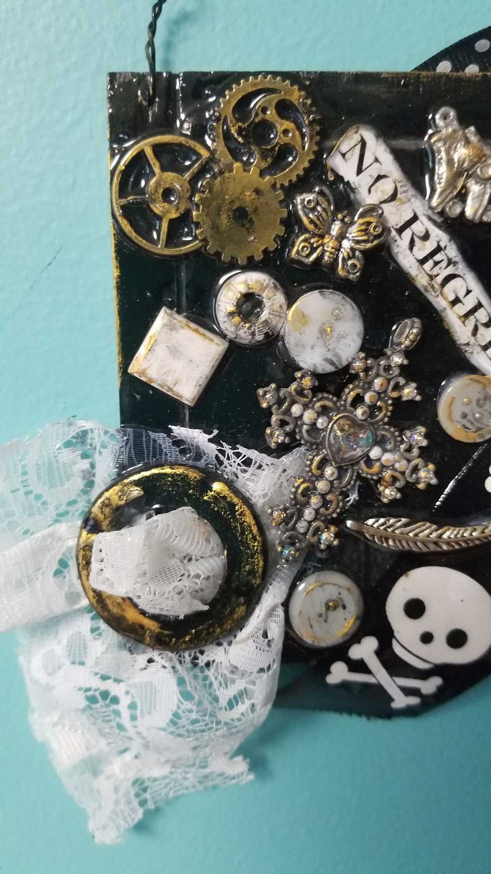 Skull & Bones Wall Plaque in Black & Gold, with Curly Wire Ribbon "No Regrets"