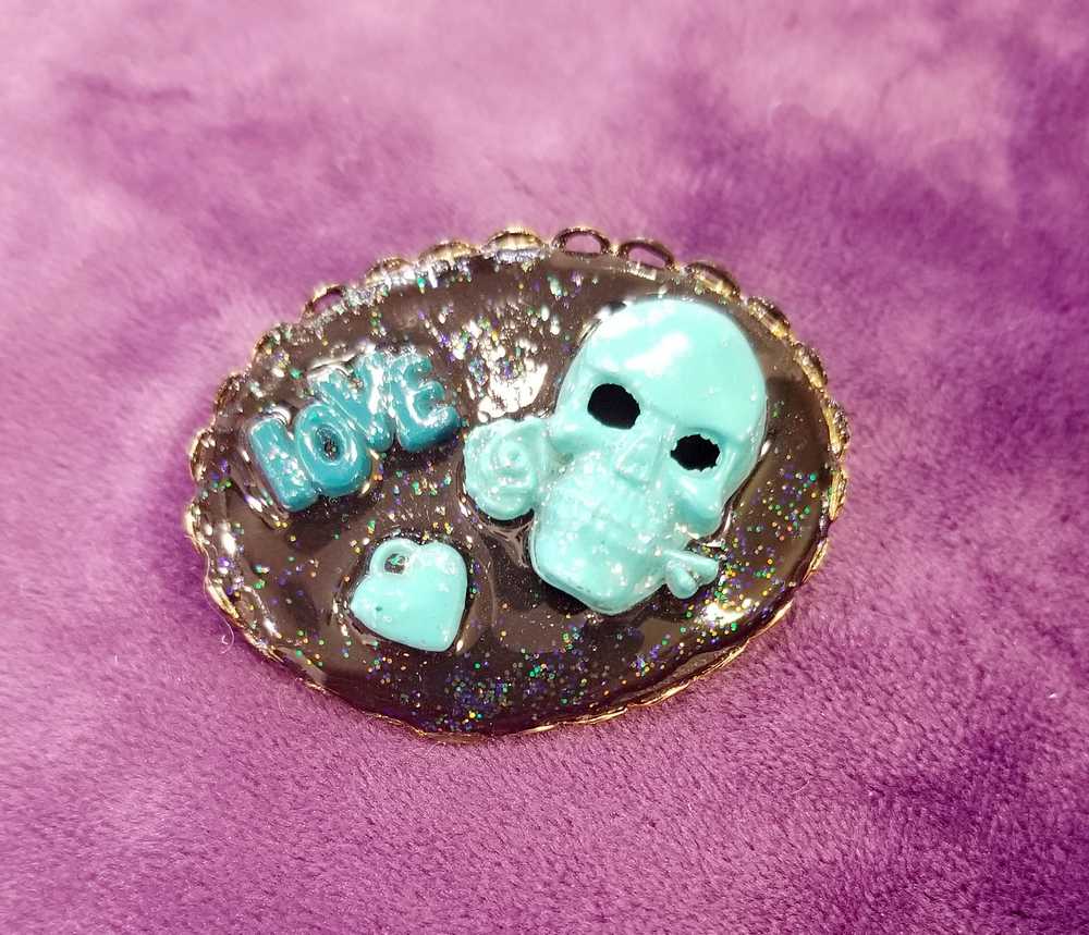 Porcelain Black Oval Shaped Brooch with Hand Painted Teal Skull, Heart & Love Charms