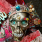 Welcome Sign With a Silver Colored Skull With  Piercings Wearing a Crown And Her Scepter