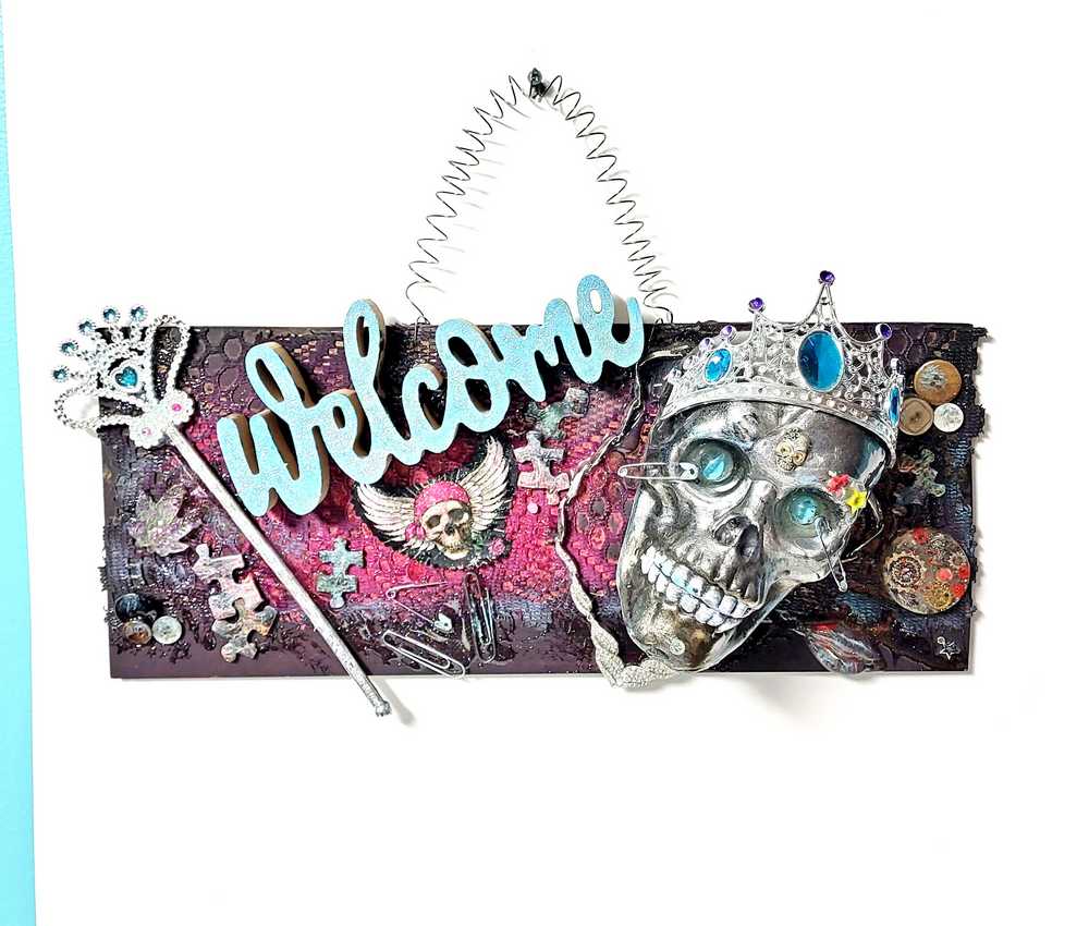 Welcome Sign With a Silver Colored Skull With  Piercings Wearing a Crown And Her Scepter