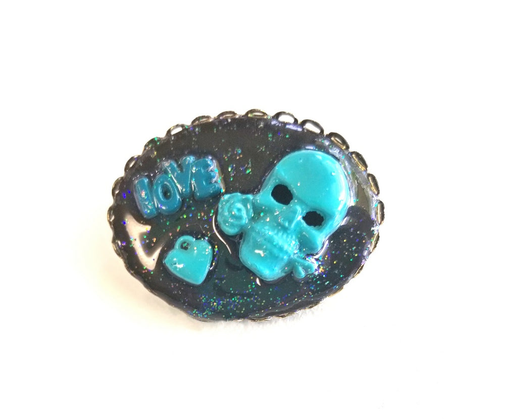 Porcelain Black Oval Shaped Brooch with Hand Painted Teal Skull, Heart & Love Charms