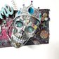 Welcome Sign With a Silver Colored Skull With  Piercings Wearing a Crown And Her Scepter