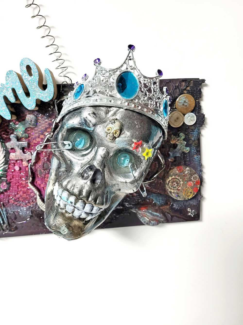 Welcome Sign With a Silver Colored Skull With  Piercings Wearing a Crown And Her Scepter