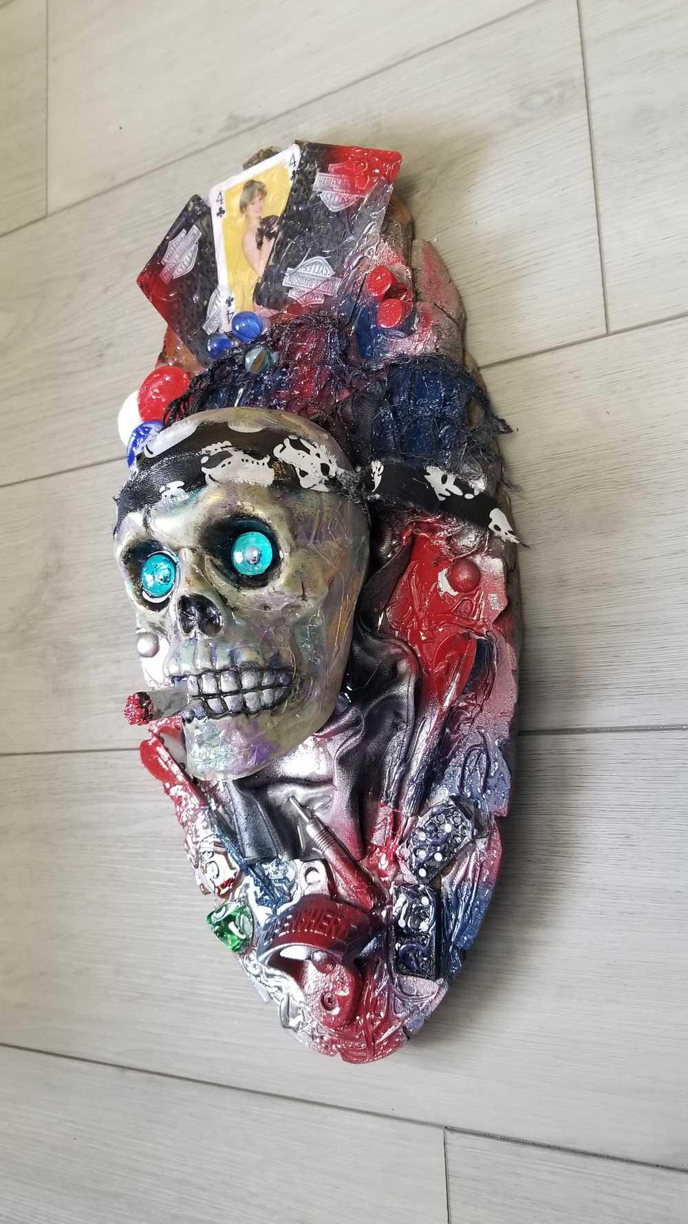 Skull Head Bottle Opener on Oval Slab of Wood, Surrounded by Darts, Dice, Poker Chips, Girlie Playing Cards, Smoking a BIg One