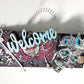 Welcome Sign With a Silver Colored Skull With  Piercings Wearing a Crown And Her Scepter