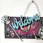 Welcome Sign With a Silver Colored Skull With  Piercings Wearing a Crown And Her Scepter