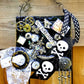 Skull & Bones Wall Plaque in Black & Gold, with Curly Wire Ribbon "No Regrets"