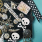 Skull & Bones Wall Plaque in Black & Gold, with Curly Wire Ribbon "No Regrets"